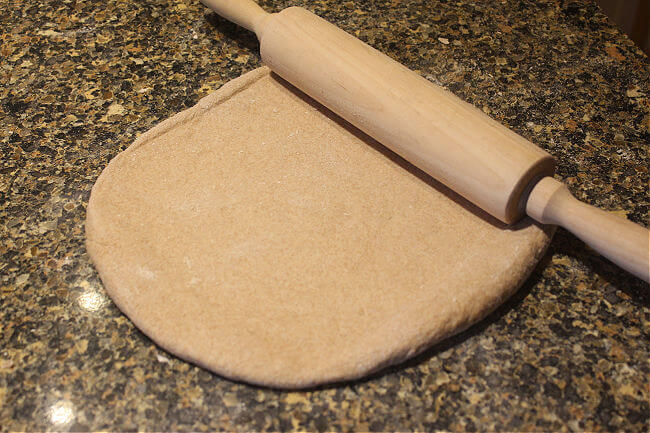 Rolling out dough on a granite countertop.