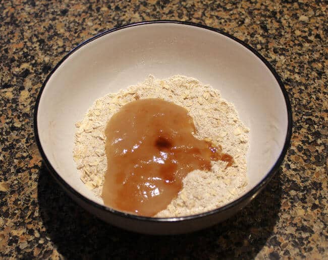 Oatmeal and applesauce mixture in a large white bowl on a granite counter.