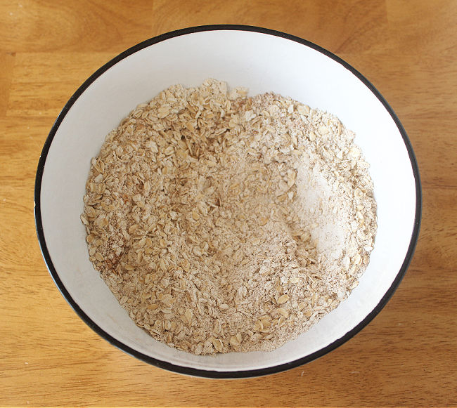 Flour, oats, salt, and baking powder in a large white bowl.