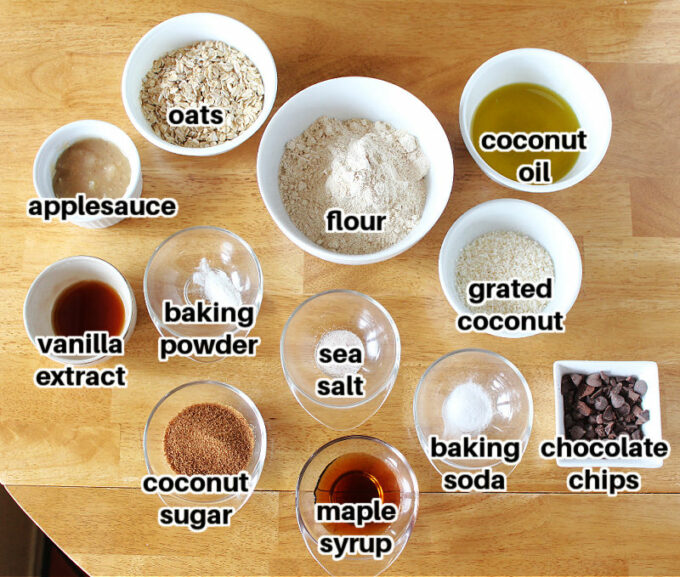 Ingredients, including flour, oats, and coconut, on a table.
