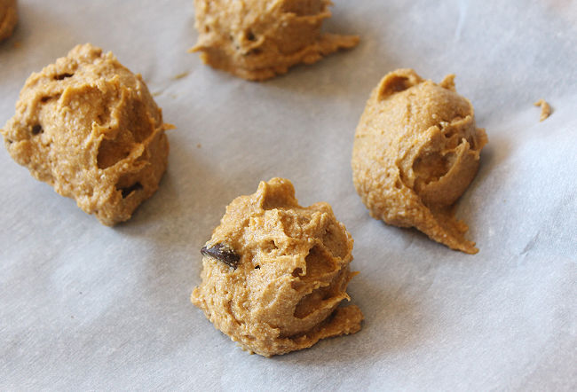 Pre-baked cookie dough on a sheet of parchment paper.