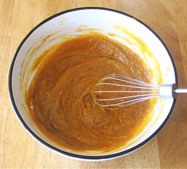 Whisking pumpkin puree with oil and maple syrup.