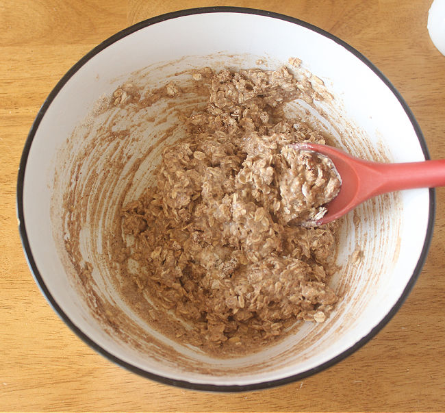 Cookie dough batter being stirred with a red spoon.