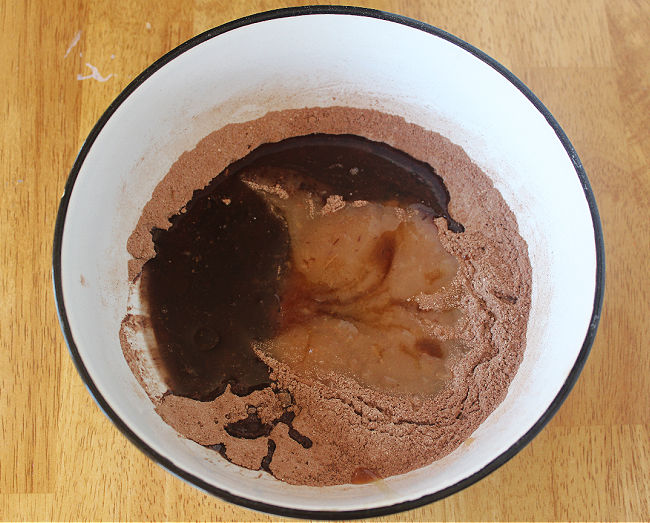 Flour, cocoa, and applesauce in a white bowl.
