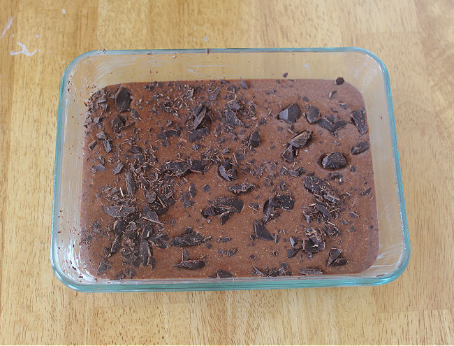 Unbaked brownie batter in a small glass baking dish.
