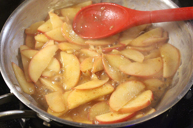 Saucy bubbly apples in a stainless steel pan.