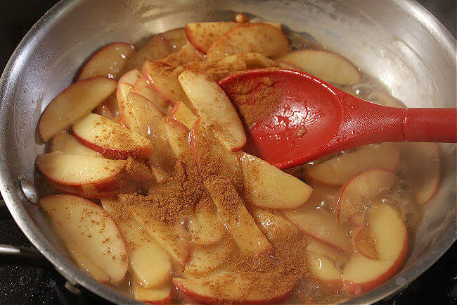 Saucy apples with cinnamon in a pan.