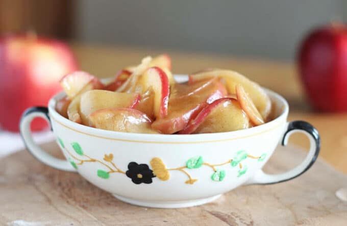 Cooked apple slices in a small porcelain bowl.