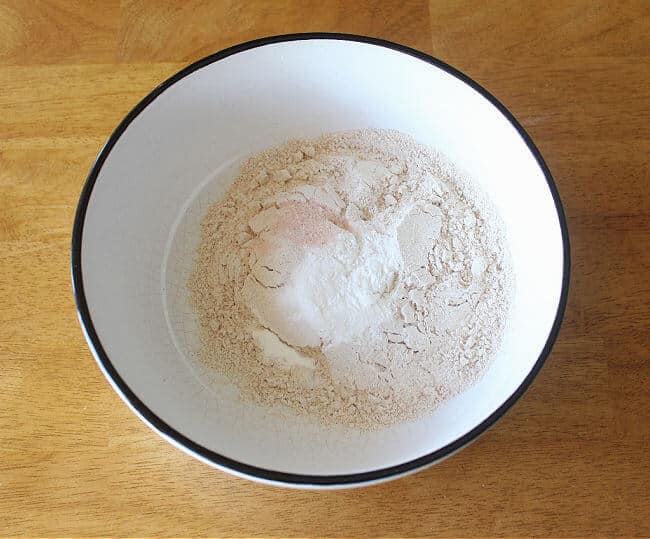 Flour, salt, and baking powder in a large white bowl.