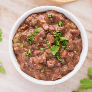 Bowl of black beans topped with cilantro.