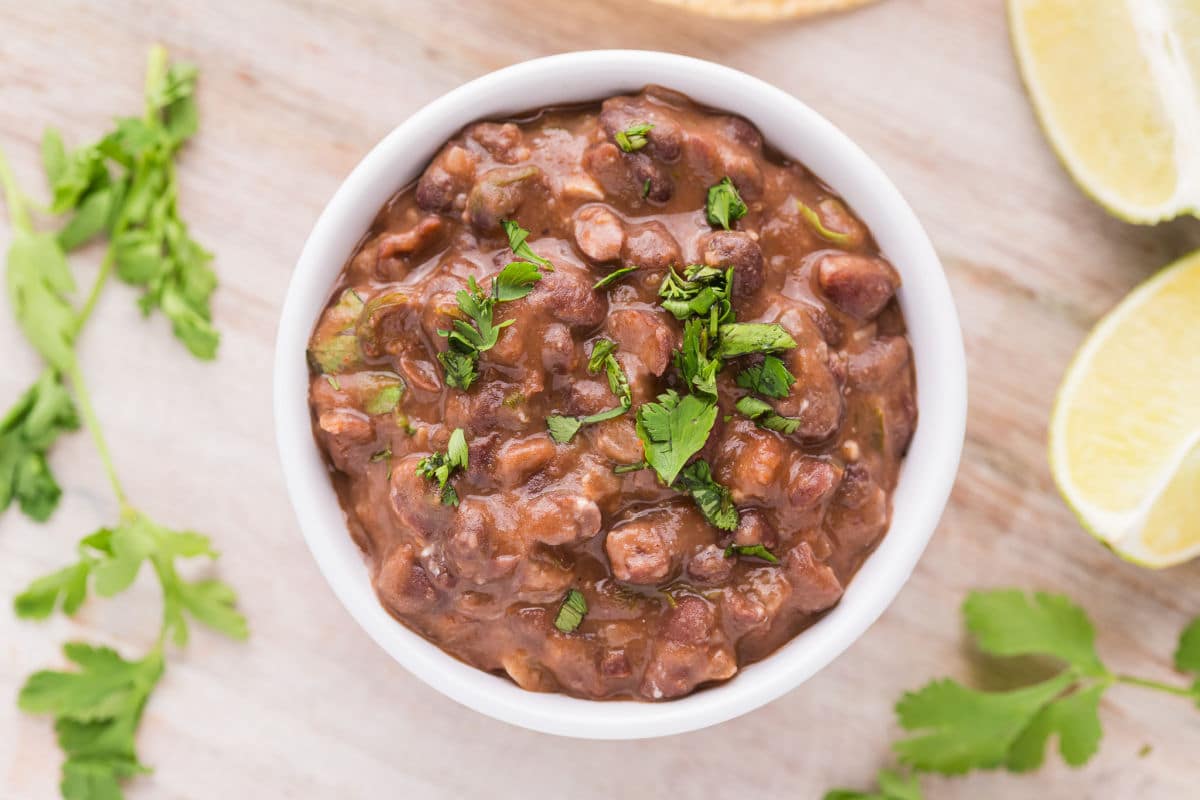 Bowl of black beans topped with cilantro.