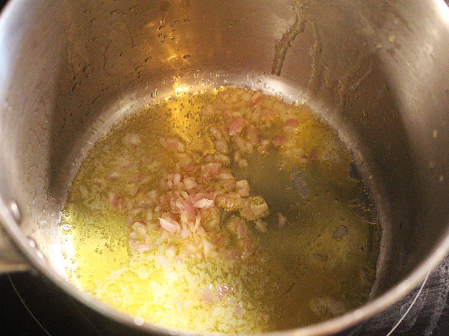 Shallot and oil cooking in a saucepan.