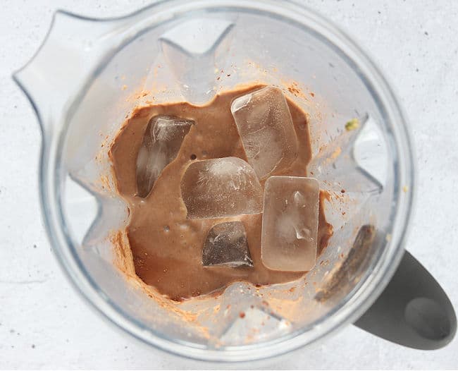 Chocolate smoothie and ice in a blender.