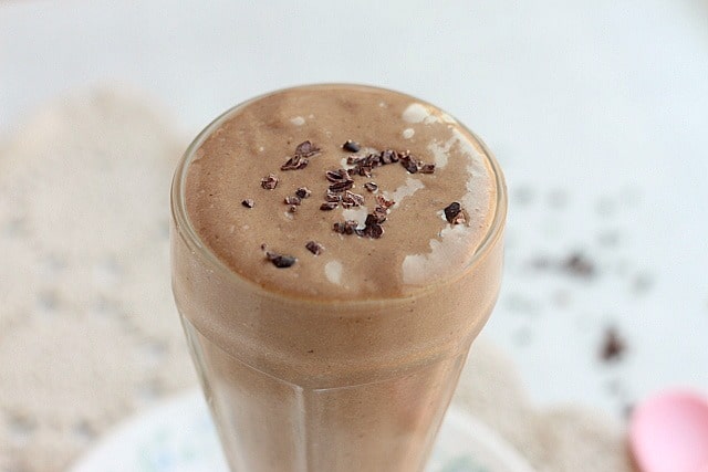 Chocolate milkshake topped with cacao nibs.