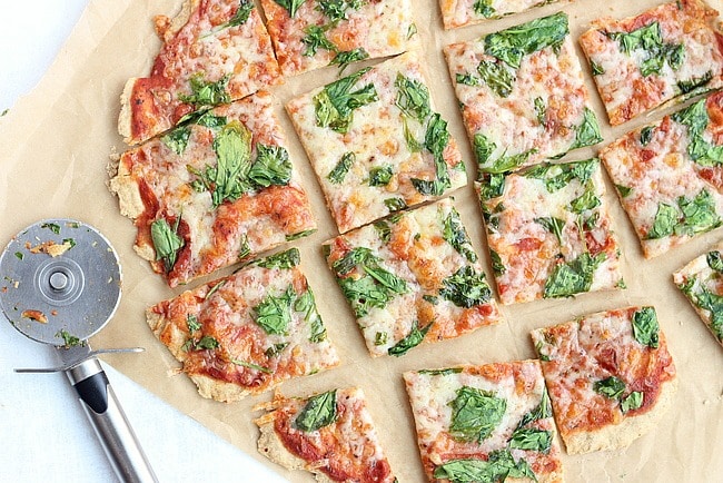 Overhead shot of thin crust pizza cut into squares.