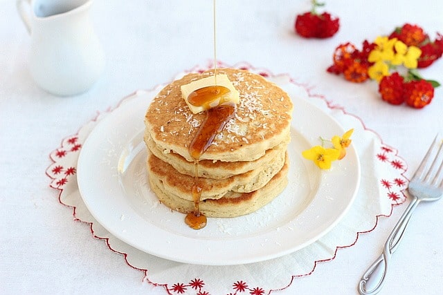 Gluten-free pancakes topped with butter and maple syrup.