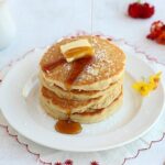 Stack of gluten-free pancakes atop a white plate.