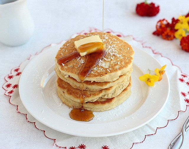 Stack of gluten-free pancakes atop a white plate. 