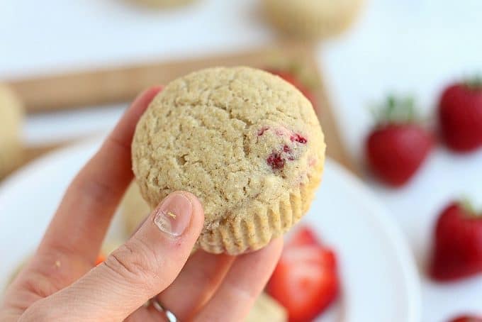 Strawberry muffin in a woman's hand.