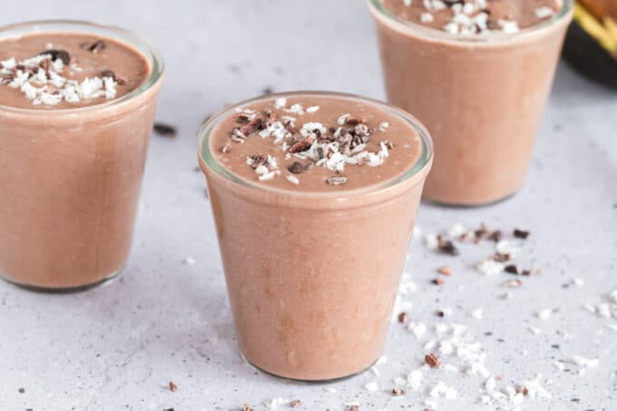 Three chocolate smoothies on a table.