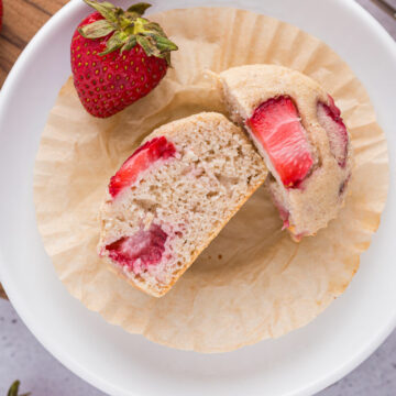 Strawberry muffin cut in half on a plate.