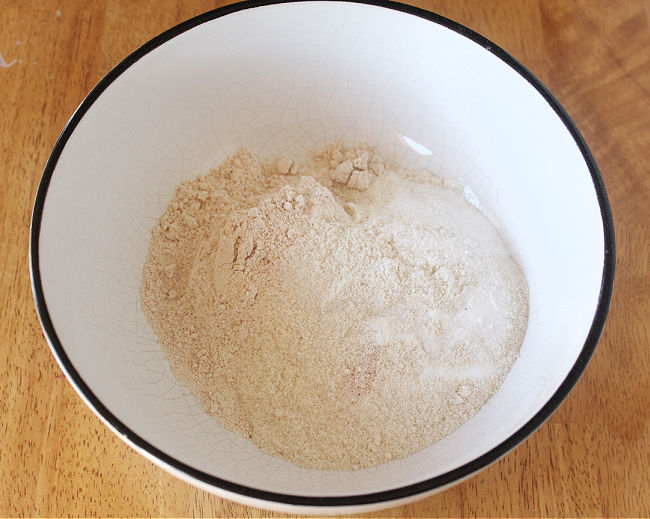 Flour and baking soda in a large white bowl.