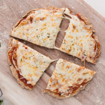 Small sliced pizza on a cutting board.