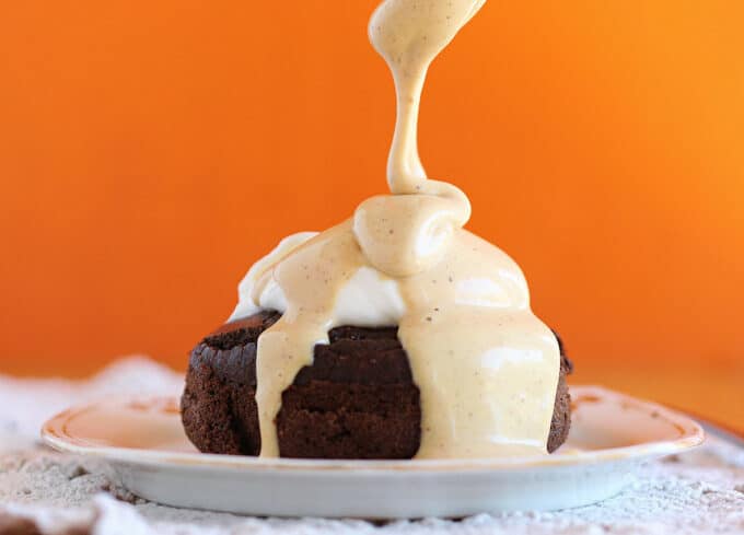 Peanut butter being drizzled over a small chocolate cake.
