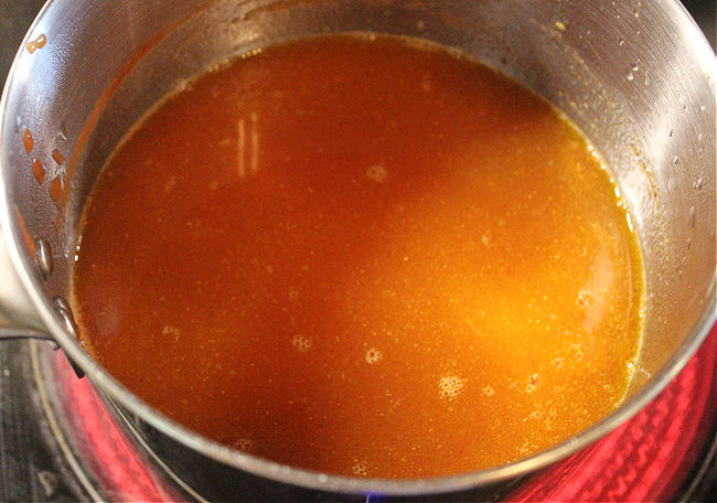 Steel pot filled with tomato sauce and water.
