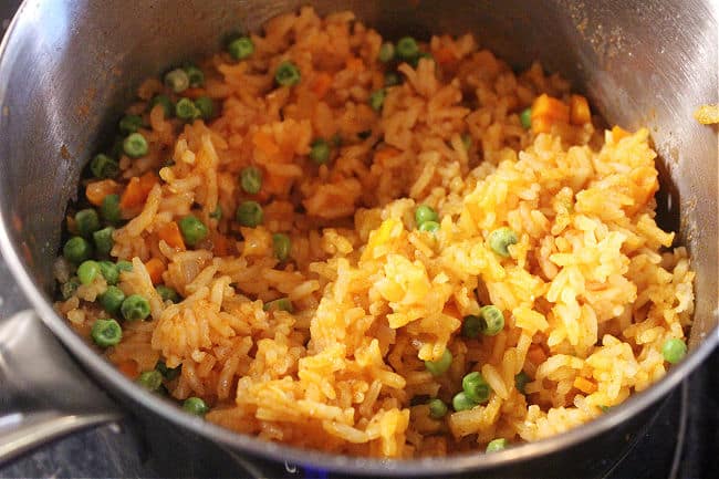 Pot full of Mexican rice with peas and carrots.
