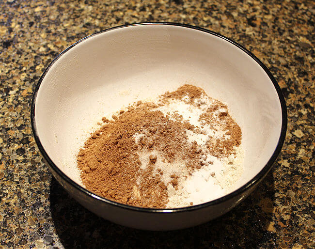 Flour, cocoa powder, baking agents, and salt in a white bowl.