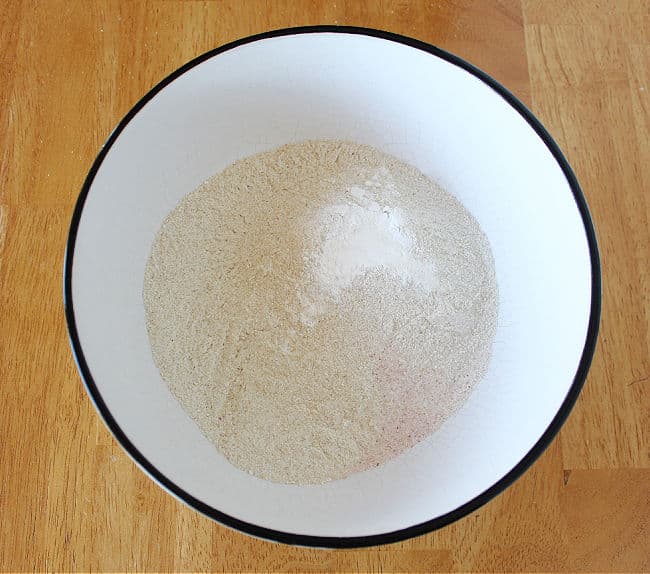 Flour and baking powder in a large white bowl.