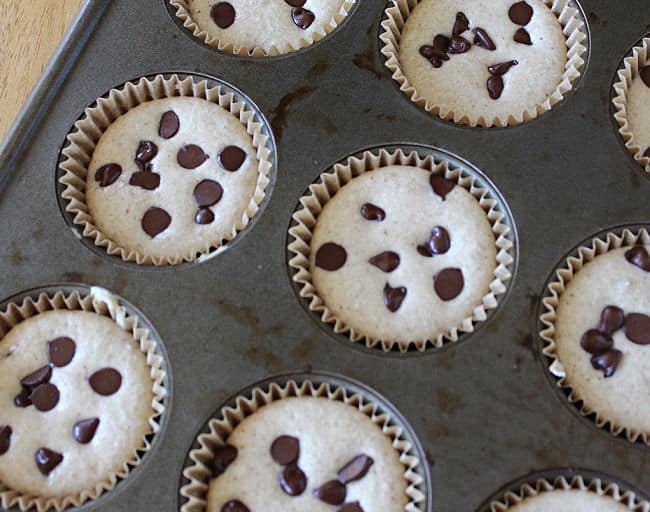Unbaked chocolate chip muffins in a muffin pan.