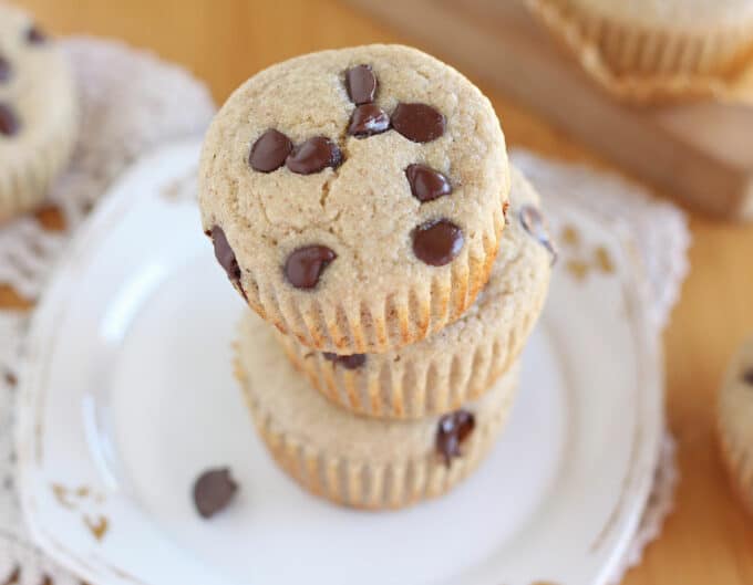 Stack of three chocolate chip muffins on a white plate.