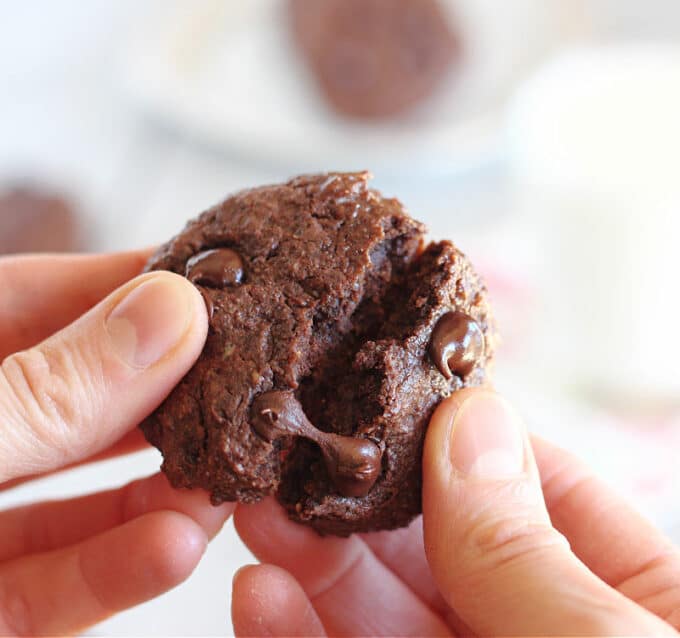 Two hands opening a chocolate cookie.
