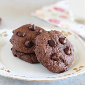 Three double chocolate cookies on a white plate.