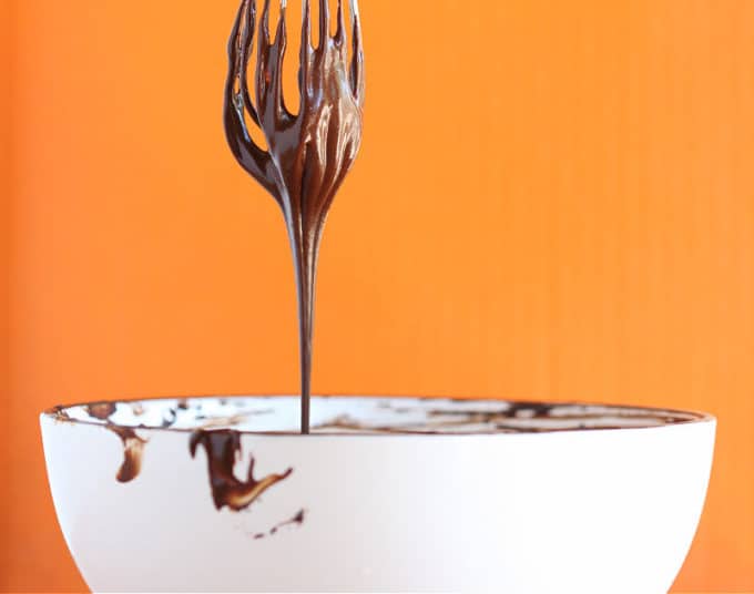 Sugar-free chocolate sauce dripping from a whisk.