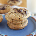 Stack of four chocolate chip cookies on a blue plate.