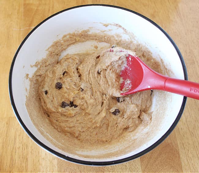 Chocolate chip cookie dough in a large white bowl.