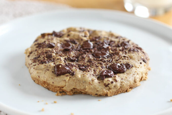 Chocolate chip cookie on a white plate.