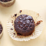 Baked chocolate muffin on a beige board.