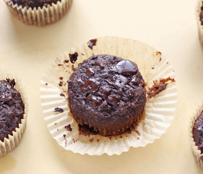 Baked chocolate muffin on a beige board.