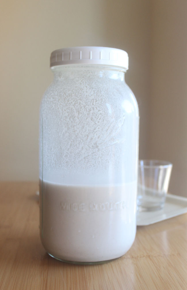 Jar of walnut milk on a table.
