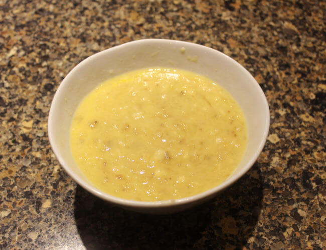 Mashed banana and milk in a bowl.