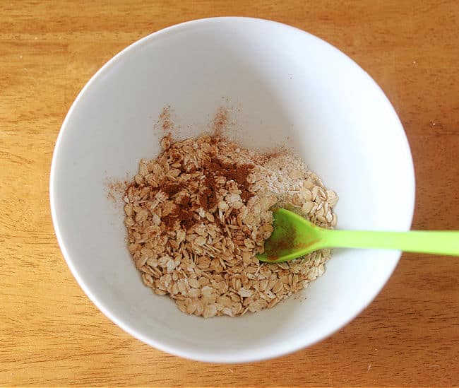 Oats, flour, and cinnamon in a white bowl.