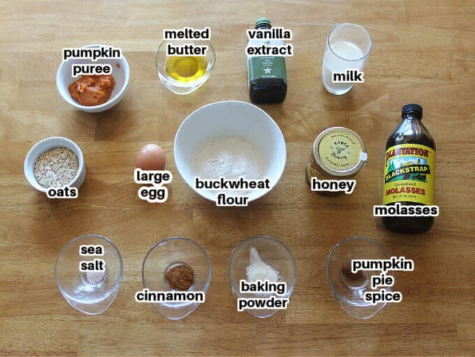 Ingredients for muffins on a wood table, including pumpkin and buckwheat flour.