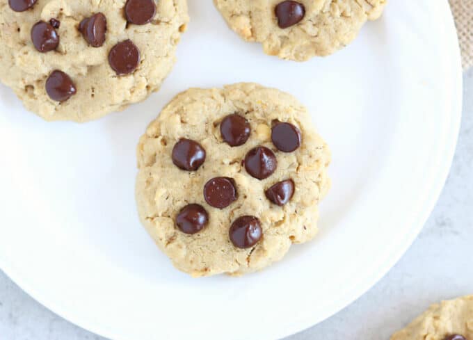 Top down view of a chocolate chip cookie on a white plate.