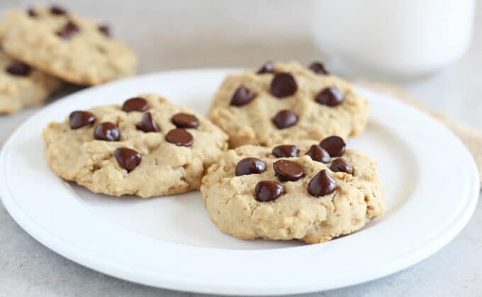 Three chocolate chip cookies on a white plate.