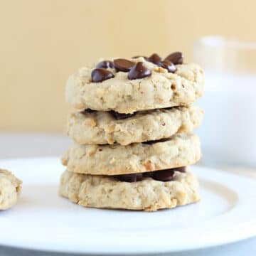 Stack of four cookies on a white plate.