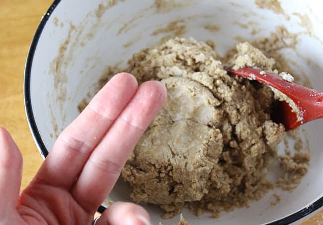 Image of two dry fingers and dough demonstrating the consistency of the dough.